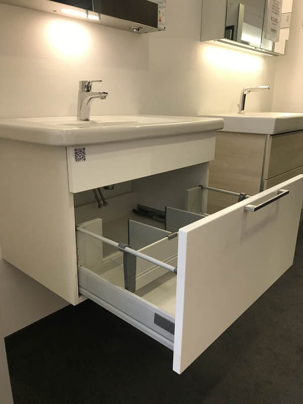 Waschbecken in weiß Unterschrank in weiß mit Spiegelschrank geöffnete Schublade von der Seite