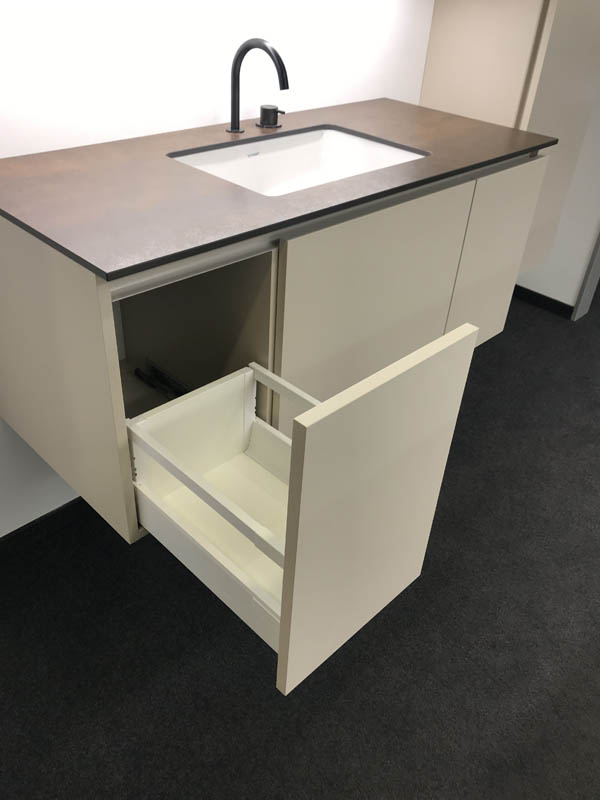 Waschtisch mit Becken in weiß Abdeckplatte in braun Unterschrank in Sand Armatur in anthrazit geöffnete Schublade
