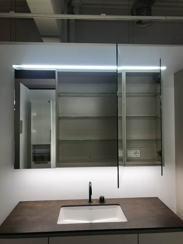 Detail Spiegelschrank mit Beleuchtung geöffnete Türen Inneneinteilung sichtbar