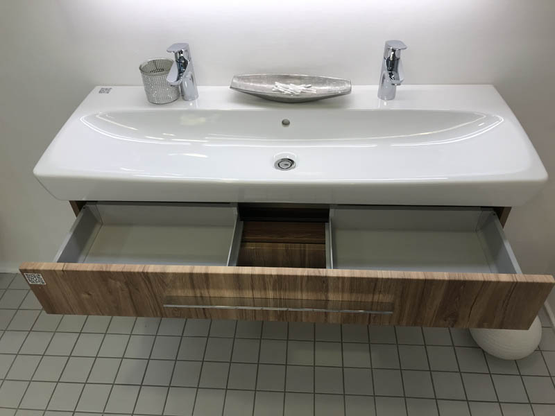 Doppel-Waschbecken in weiß Armaturen in Chrom Unterschrank in Holzoptik dunkel geöffnete Schublade