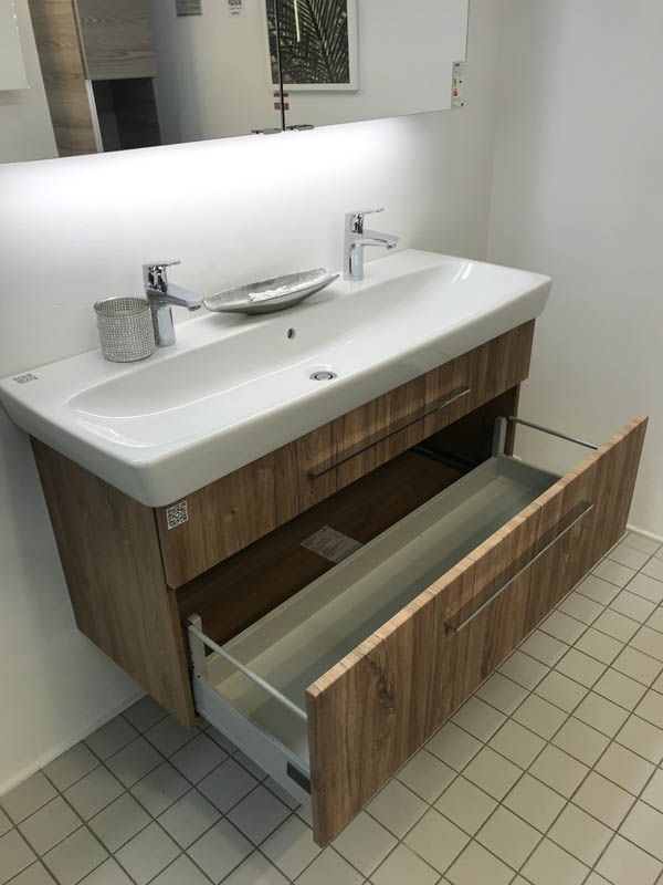 Doppel-Waschbecken in weiß Armaturen in Chrom Unterschrank in Holzoptik dunkel geöffneter Auszug Seitenansicht