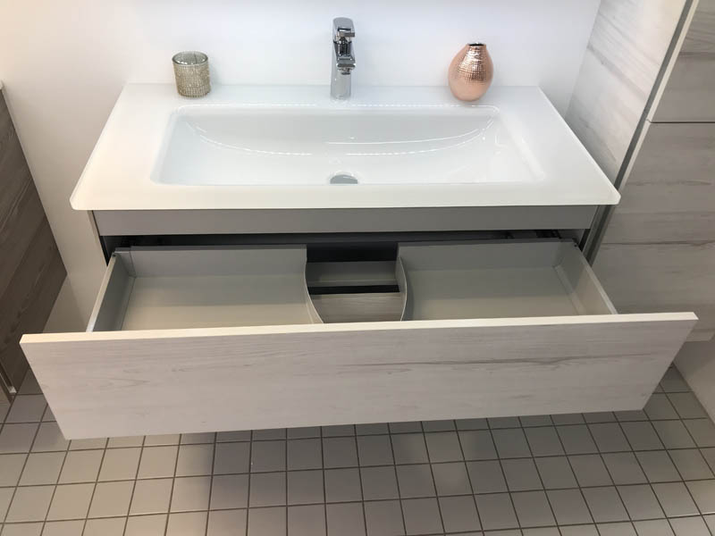 Badmöbel Waschtischanlage Waschbecken in weiß Armatur in Chrom Unterschrank in Holzoptik hell geöffnete Schublade