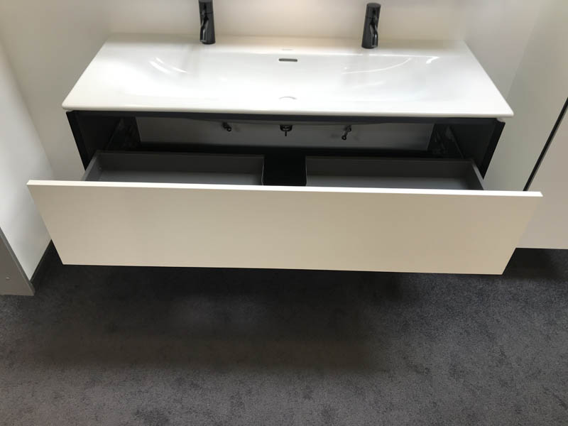 Doppel-Waschbecken in weiß Armaturen in schwarz Unterschrank in weiß mit schwarzen Kanten geöffnete Schublade