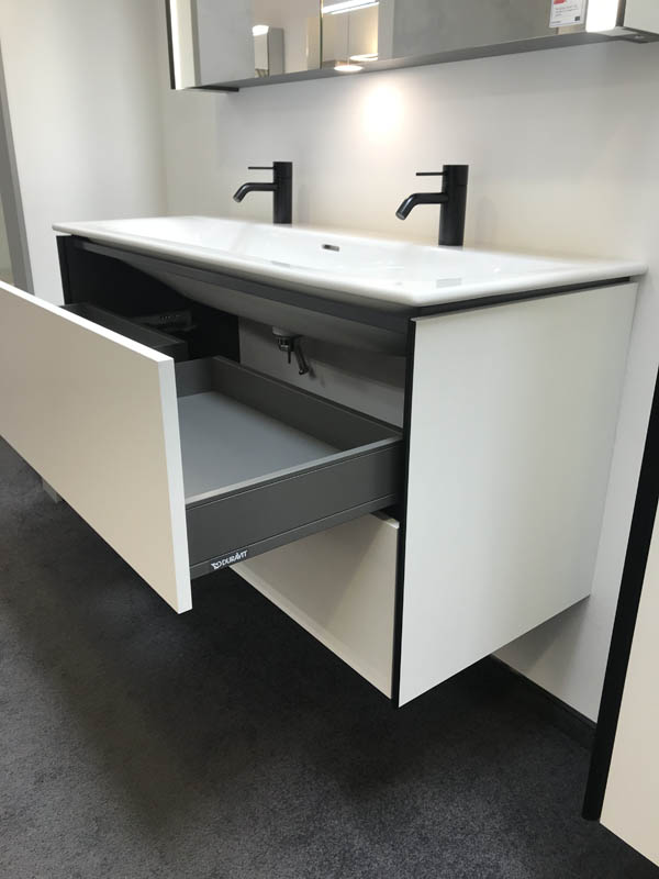 Doppel-Waschbecken in weiß Armaturen in schwarz Unterschrank in weiß mit schwarzen Kanten geöffnete Schublade Seitenansicht
