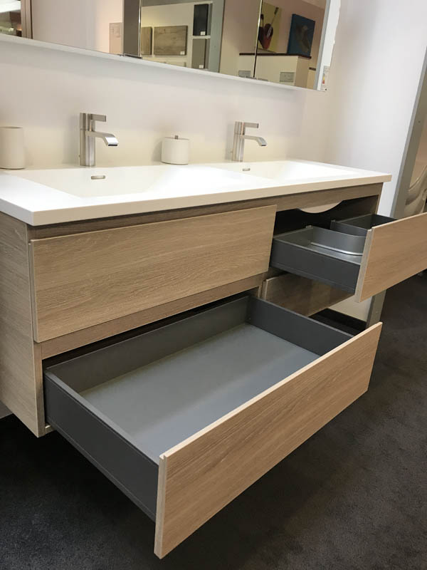 Doppel-Waschbecken in weiß Armaturen in Chrom Unterscharnk in Holzoptik geöffnete Schubladen