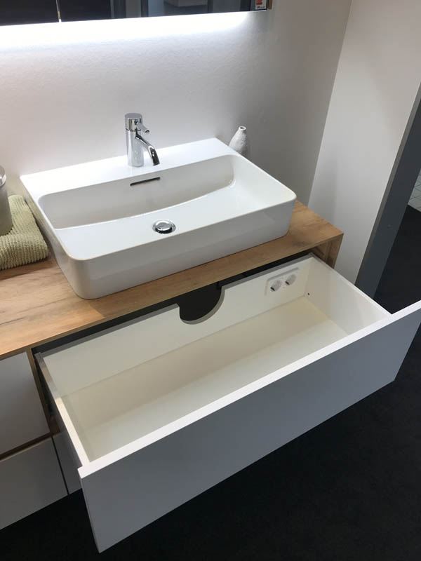 Aufsatzwaschbecken in weiß Armaturen in Chrom Unterschrank Korpus Holzoptik Front in weiß geöffnete Schublade