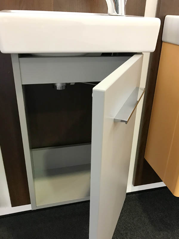 Bäderausstellung Ottenbruch Handwaschbecken weiß geöffneter Badmöbel-Unterschrank in grau