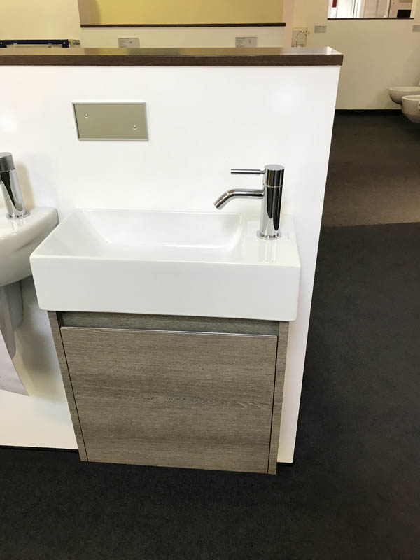 Bäderausstellung Ottenbruch kleines Handwaschbecken in weiß Armatur in Chrom Unterschrank in Holzoptik