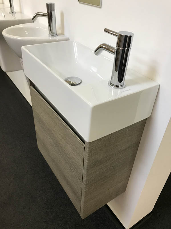 Bäderausstellung Ottenbruch kleines Handwaschbecken in weiß Armatur in Chrom Unterschrank in Holzoptik
