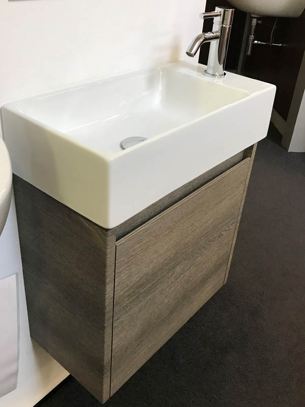 Bäderausstellung Ottenbruch kleines Handwaschbecken in weiß Armatur in Chrom Unterschrank in Holzoptik
