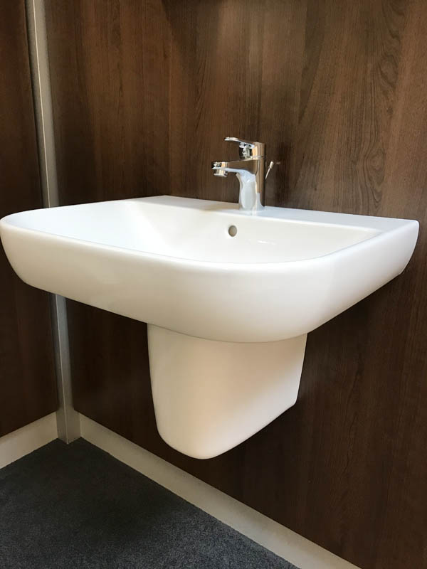 Bäderausstellung Ottenbruch Waschbecken in weiß mit Verkleidung Armatur in Chrom