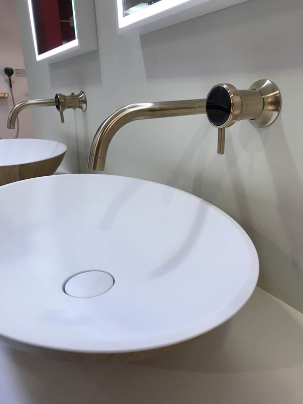 Bad hochwertig modern Aufsatzwaschbecken innen weiß aus Corian außen aus Holz Wandarmaturen goldfarben