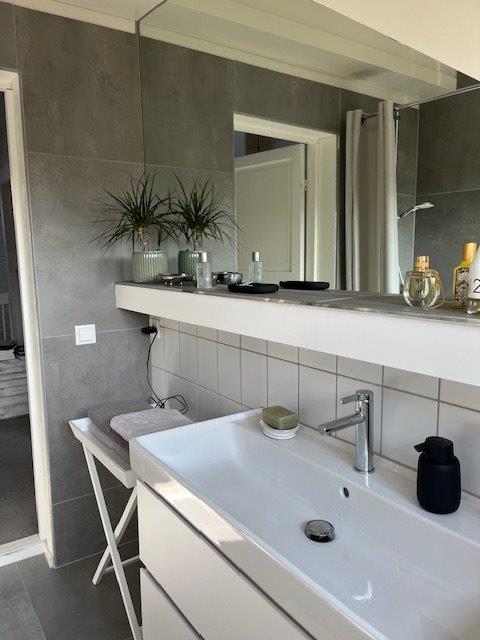 Referenzbild graues kleines Bad Dachschräge Waschtisch in weiß Unterschrank in weiß eingebauter Spiegel